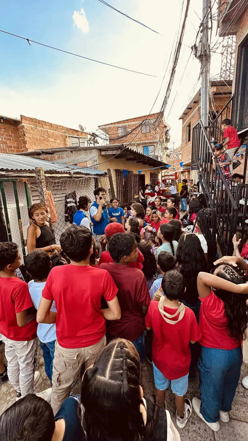 Niños con camisetas rojas reunidos en una calle angosta del barrio