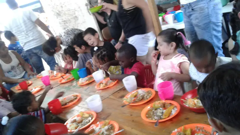 Niños almorzando en platos de colores alrededor de una mesa