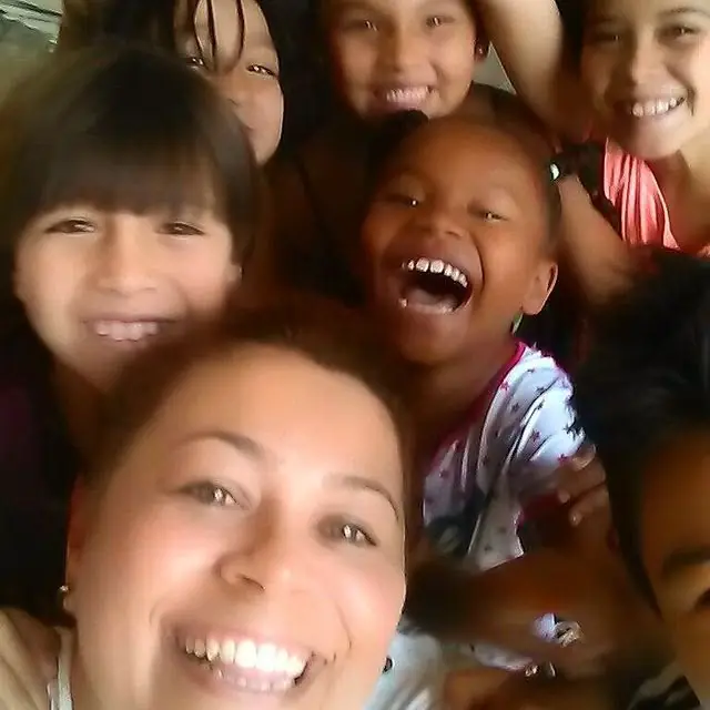 Selfie de una voluntaria con niñas riéndose