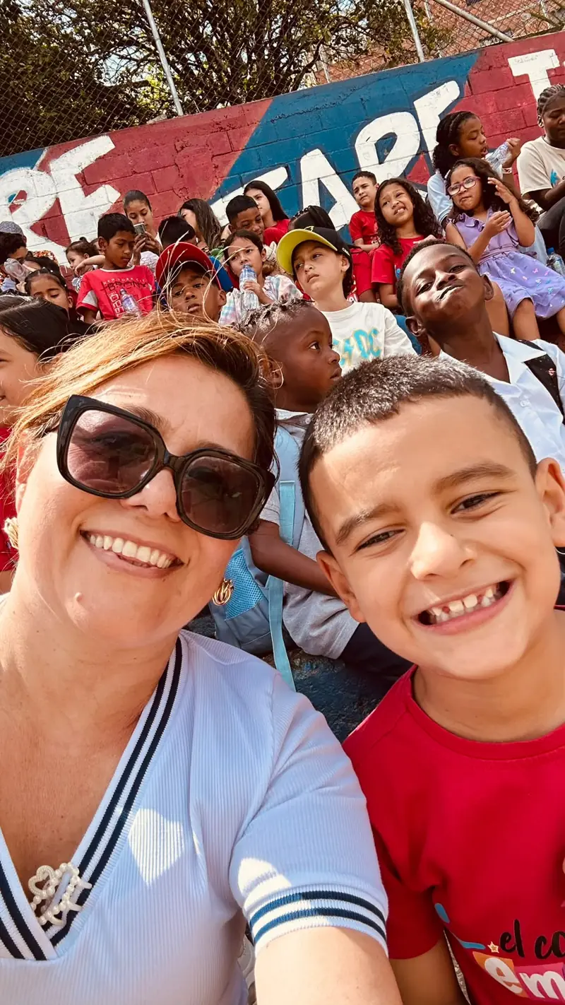 Selfie de una voluntaria con un niño de camiseta roja del comedor
