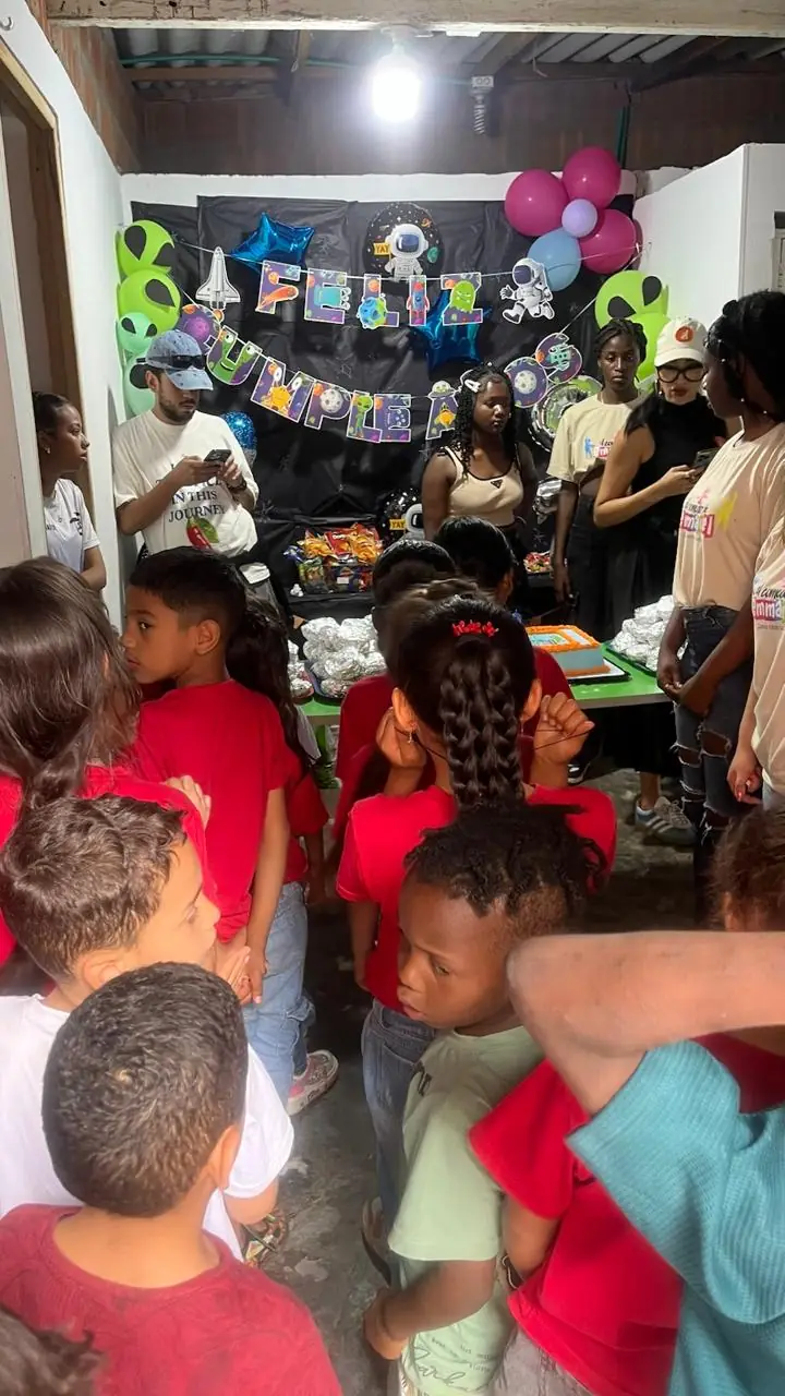 Niños en fila durante la celebración del cumpleaños del comedor, con globos y decoración del espacio