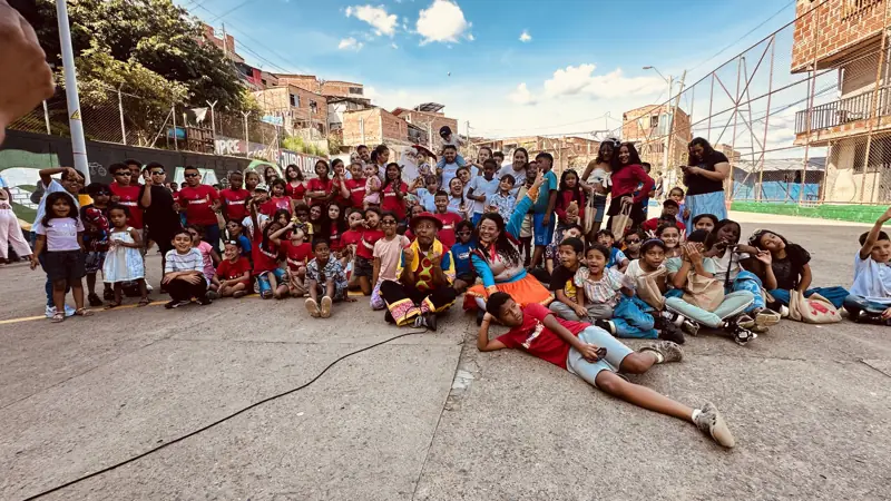 Decenas de niños y adultos reunidos en una cancha del barrio
