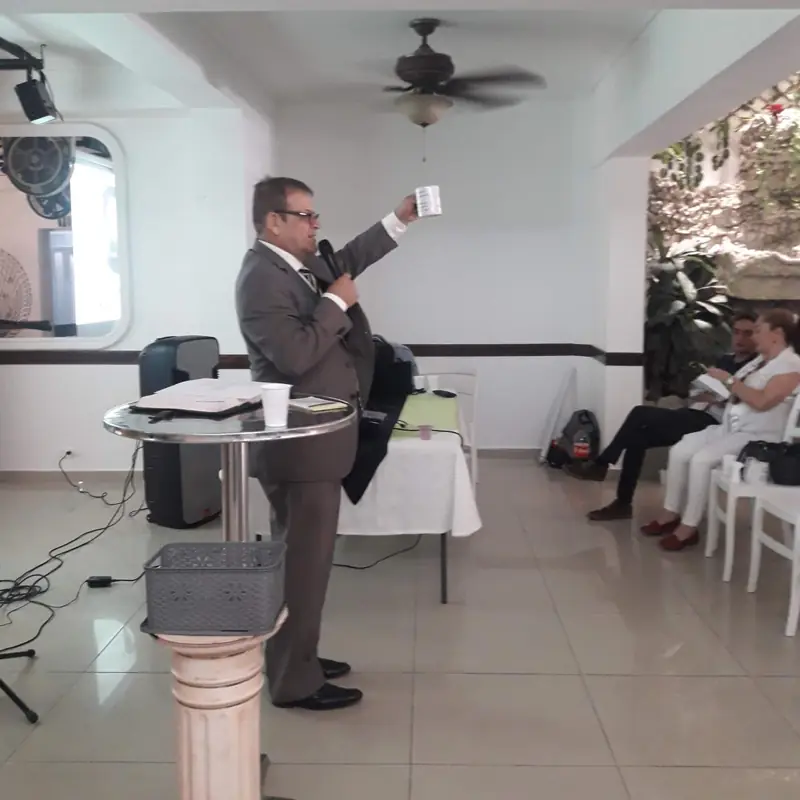 A speaker with a microphone in front of a group of adults