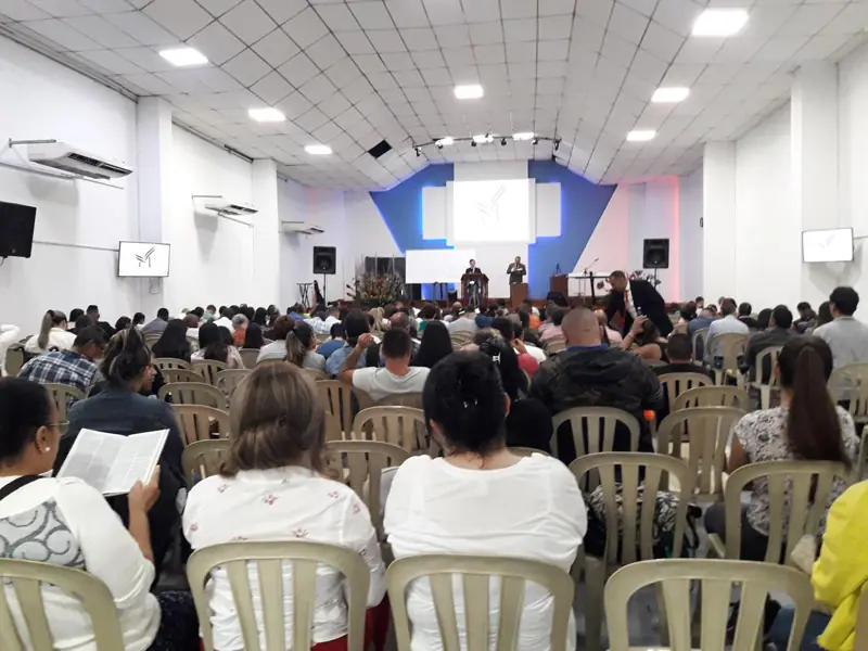A full church with people seated facing the stage