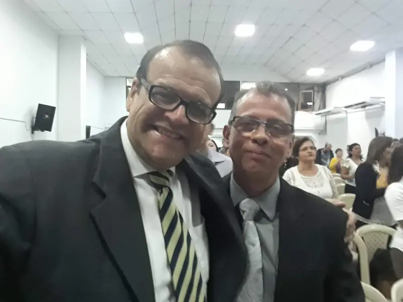 Two men in suits smiling inside a church